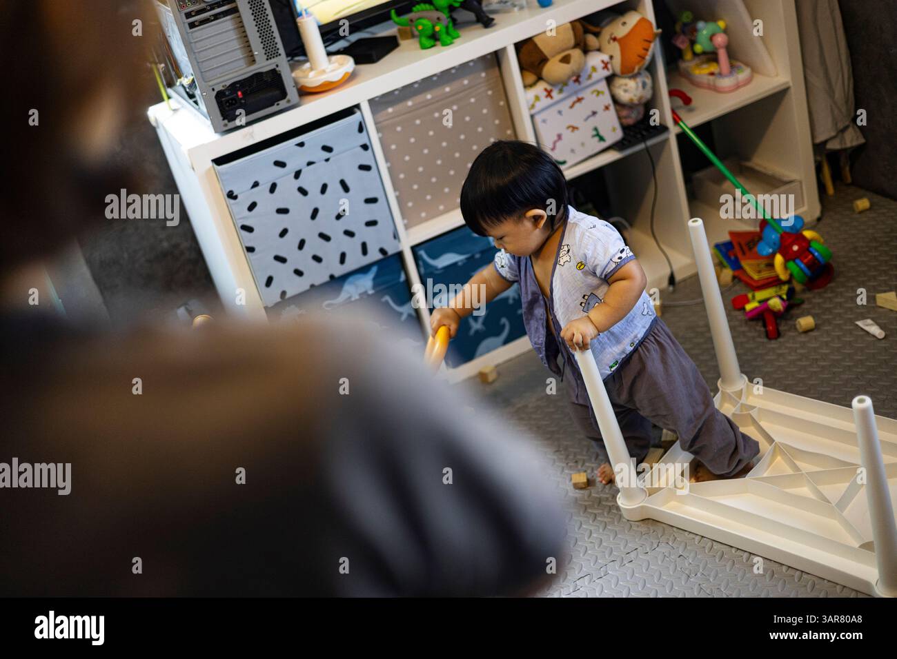 Maman regarde son enfant a fait Un désordre dans la salle, fond pour la publicité et le papier peint dans la scène relaxion et style de vie. Banque D'Images