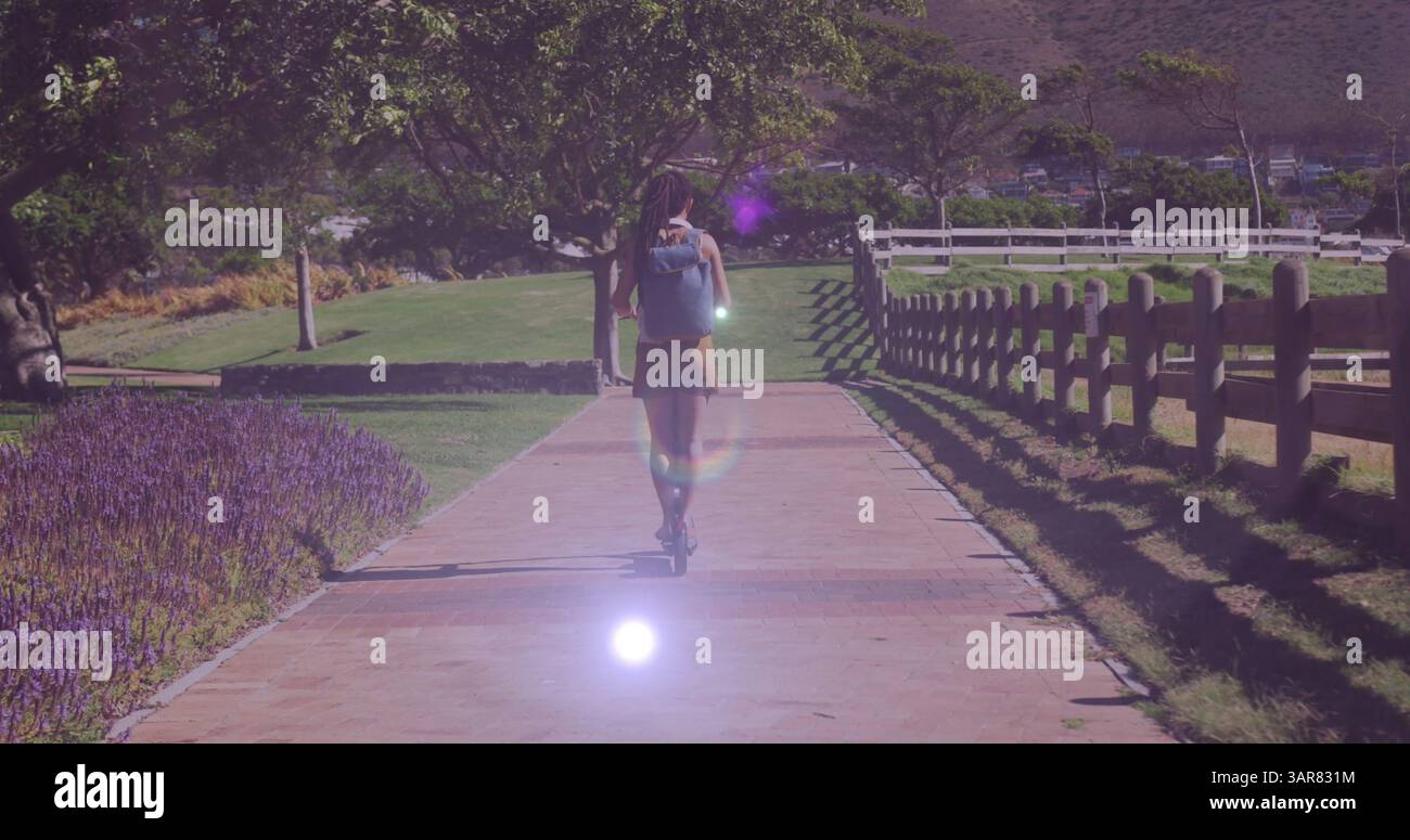 Image de taches lumineuses sur la femme biraciale chevauchant scooter Banque D'Images