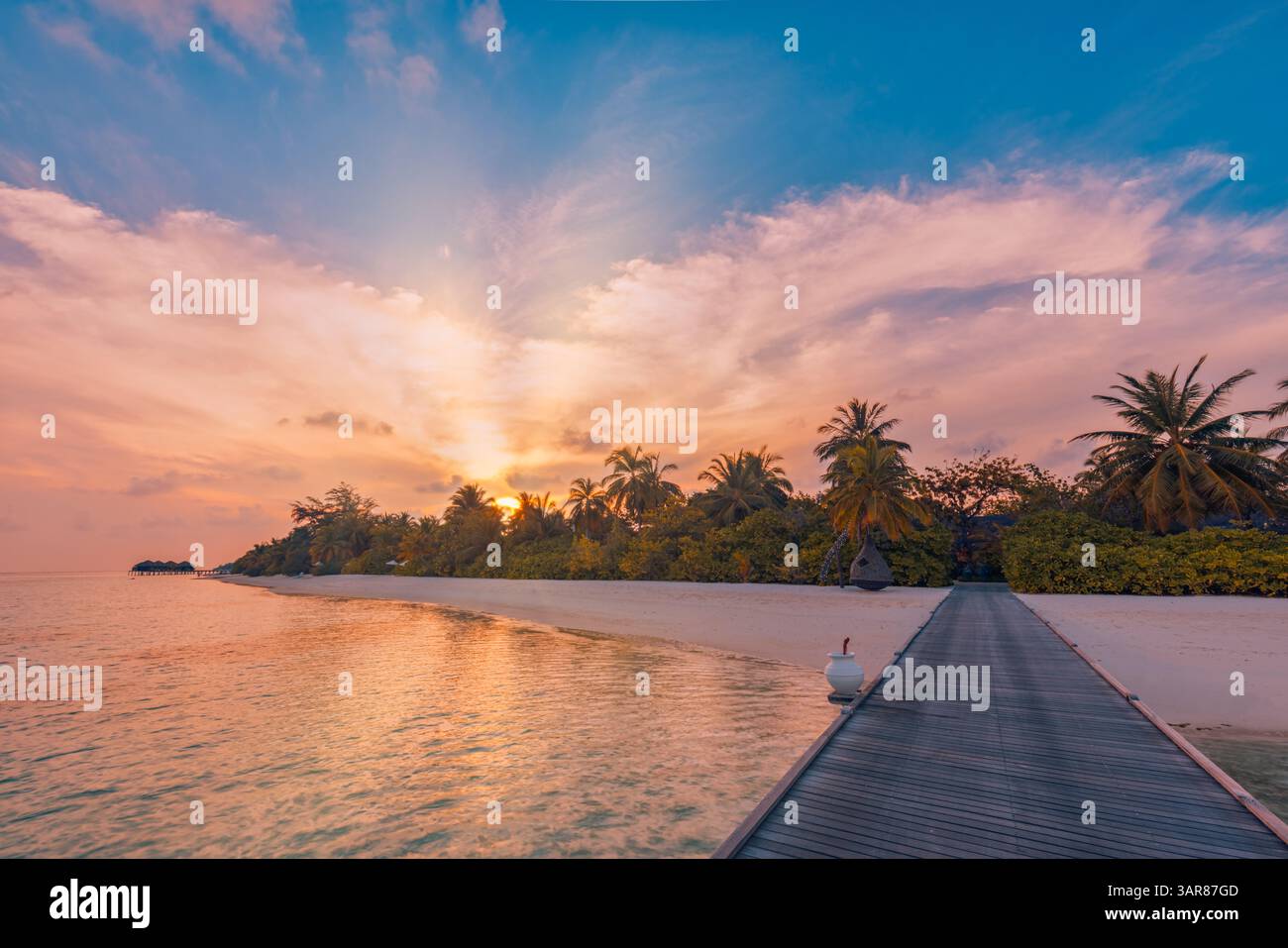 Coucher de soleil sur la magnifique jetée aux Maldives, beauté de l'île tropicale scintillante ciel nuages de mer immaculée, vues romantiques sereines. Magnifique paysage d'été Banque D'Images