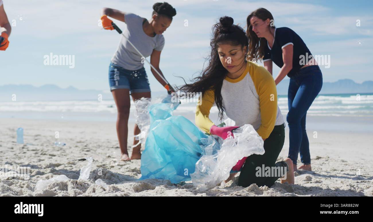 Image d'icônes de globe sur diverses volontaires féminines ramassant des ordures sur la plage Banque D'Images