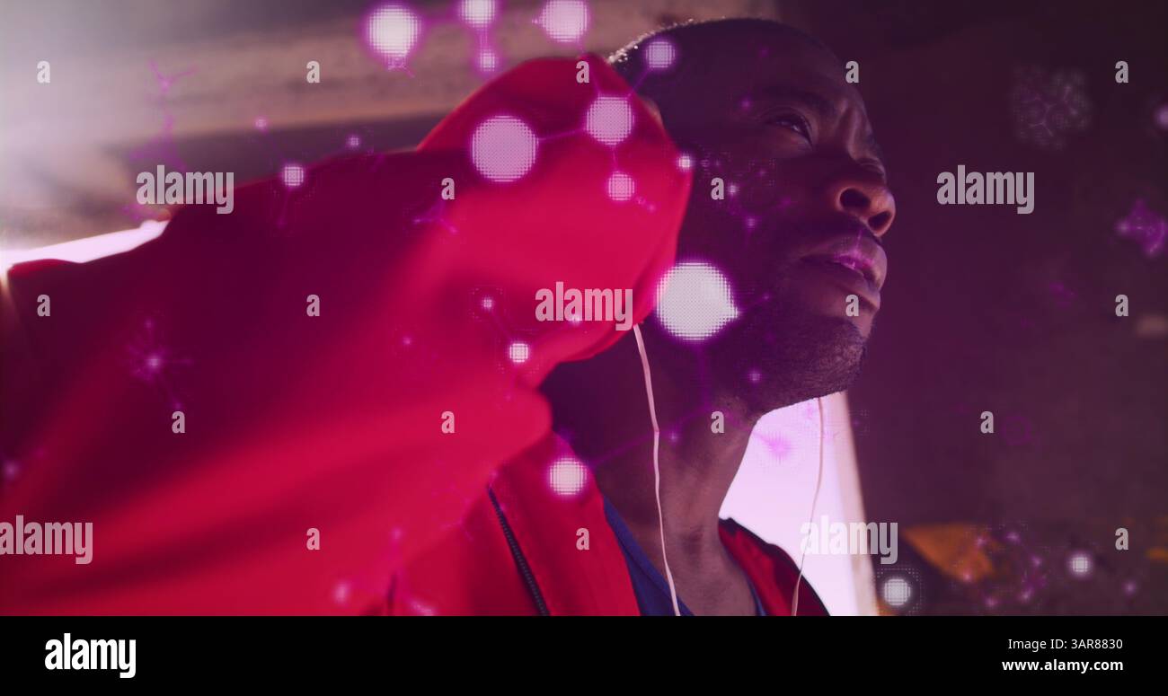 Structures moléculaires brillantes flottant contre un boxeur afro-américain portant des écouteurs Banque D'Images