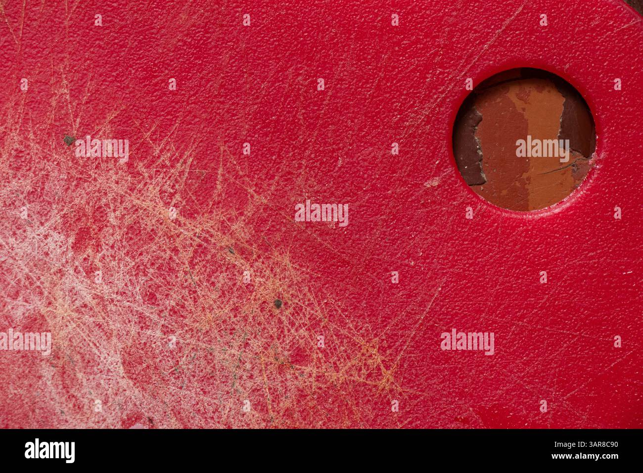 Planche à découper de cuisine en plastique rouge avec des rayures et des coupures en gros plan de fond Banque D'Images