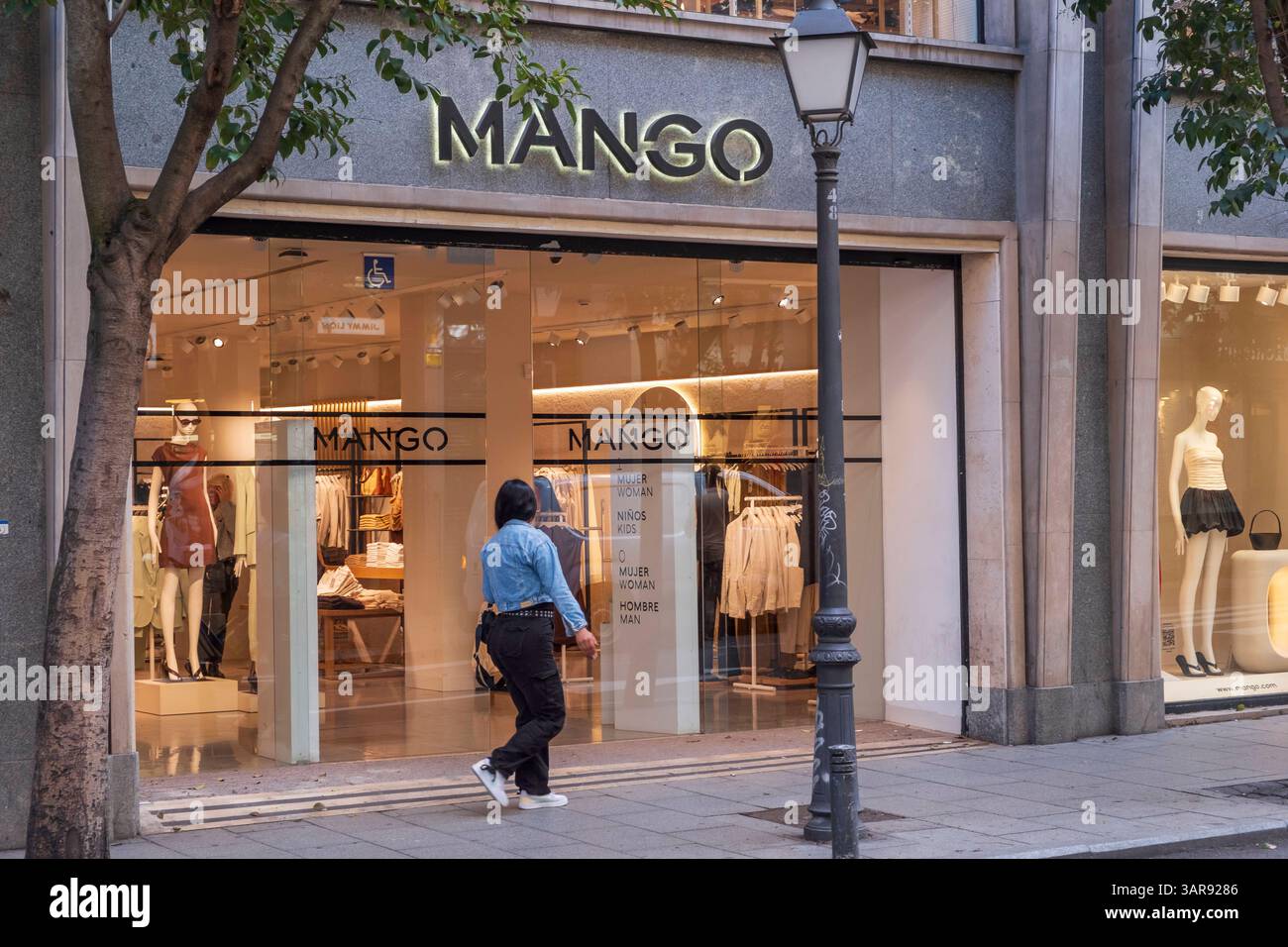 Filiale der Modemarke MANGO im Zentrum von Madrid. Mangue bzw. Die Punto Fa, S.L. ist ein multinationaler Modekonzern mit Stammsitz nördlich von Barcelona, der sich dem Design, der Herstellung und dem Verkauf von Damen- bzw. Herrenmode und Accessoires widmet. Mango ist nach Inditex Zara der zweitgrößte spanische Modekonzern und steuert von der Firmenzentrale in Barcelona aus ein weltweites Netz eigener und als franchise betriebener Einzelhandelsgeschäfte. *** Magasin de la marque de mode MANGUE dans le centre de Madrid. Mango, ou Punto Fa, S.L. est un groupe de mode multinational dont le siège social est situé au nord de Barce Banque D'Images