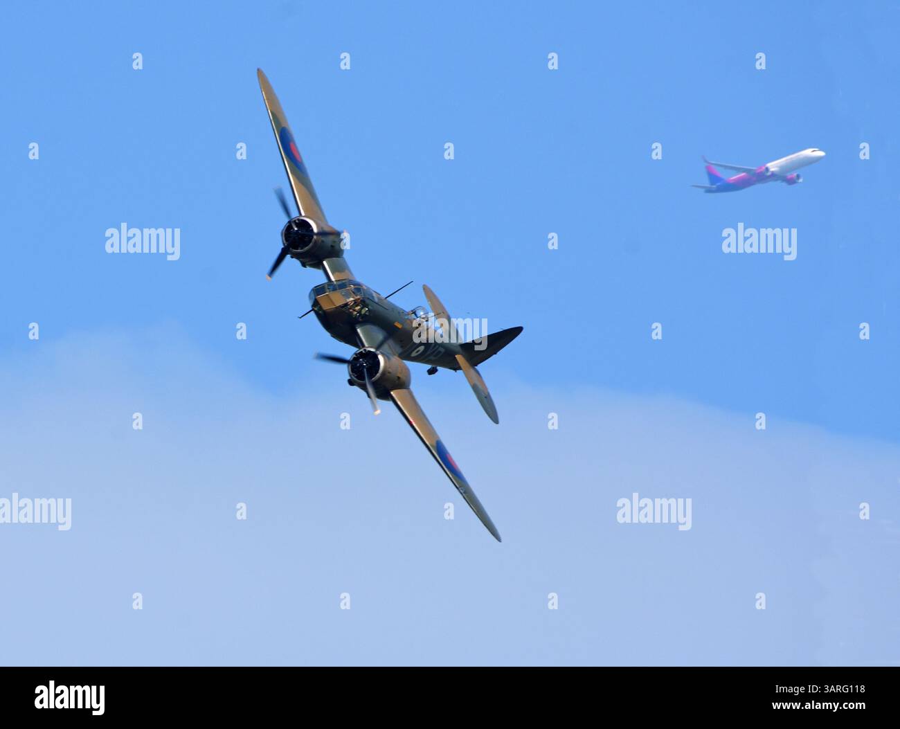 Vintage Bristol Blenheim MK. SI avion en vol avec avion de ligne de passagers moderne en arrière-plan. Banque D'Images