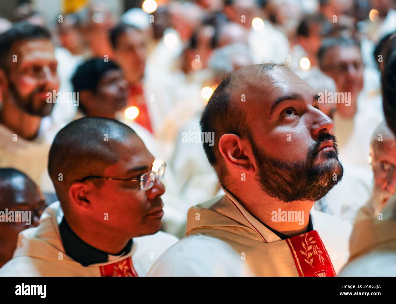 Jérusalem, Israël, 17 avril, 2025 prêtres catholiques vêtus de robes blanches et tenant des bougies prennent part à la cérémonie traditionnelle de lavage des pieds à l'église du Saint-Sépulcre, commémorant Jésus lavant les pieds de ses disciples le jeudi Saint. Un moine regardant vers le haut est au centre. Crédit : Yoram Biberman / Alamy Live News Banque D'Images