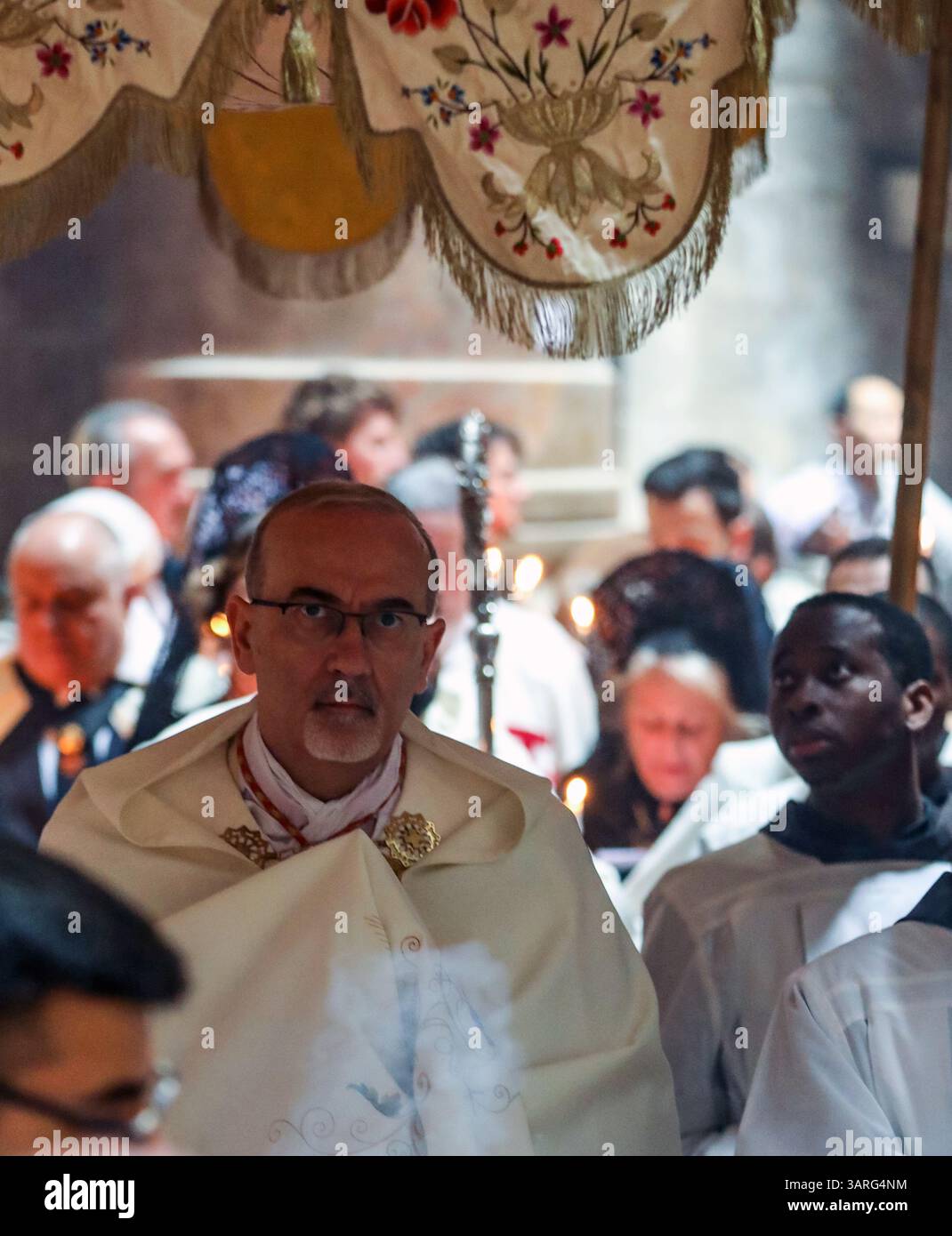 Jérusalem, Israël, 17 avril 2025 le Cardinal Pierbattista Pizzaballa marchant sous une verrière avec des prêtres catholiques vêtus de robes blanches, tenant des bougies, participe à la traditionnelle cérémonie de lavage des pieds à l'église du Saint-Sépulcre, commémorant Jésus lavant les pieds de ses disciples le jeudi Saint. Crédit : Yoram Biberman / Alamy Live News Banque D'Images