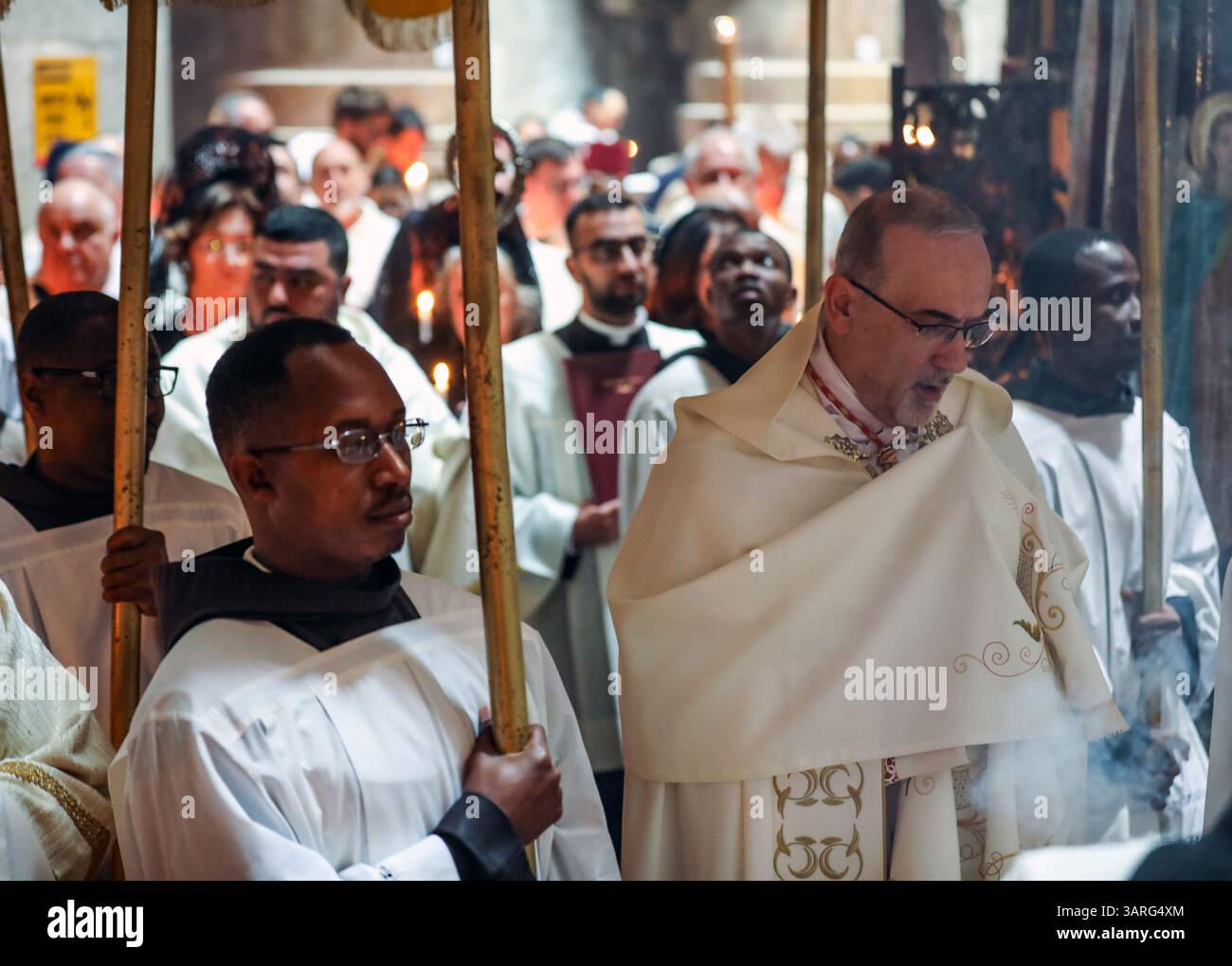 Jérusalem, Israël, 17 avril 2025 le Cardinal Pierbattista Pizzaballa marchant sous une verrière avec des prêtres catholiques vêtus de robes blanches, tenant des bougies, participe à la traditionnelle cérémonie de lavage des pieds à l'église du Saint-Sépulcre, commémorant Jésus lavant les pieds de ses disciples le jeudi Saint. Crédit : Yoram Biberman / Alamy Live News Banque D'Images