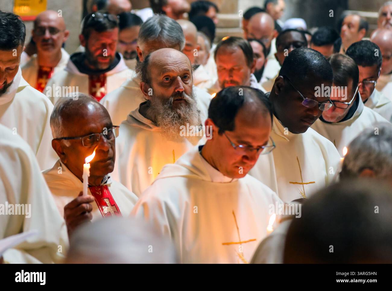 Jérusalem, Israël, 17 avril, 2025 prêtres catholiques vêtus de robes blanches et tenant des bougies prennent part à la cérémonie traditionnelle de lavage des pieds à l'église du Saint-Sépulcre, commémorant Jésus lavant les pieds de ses disciples le jeudi Saint. Des moines de différents continents peuvent être vus sur la photo crédit : Yoram Biberman / Alamy Live News Banque D'Images