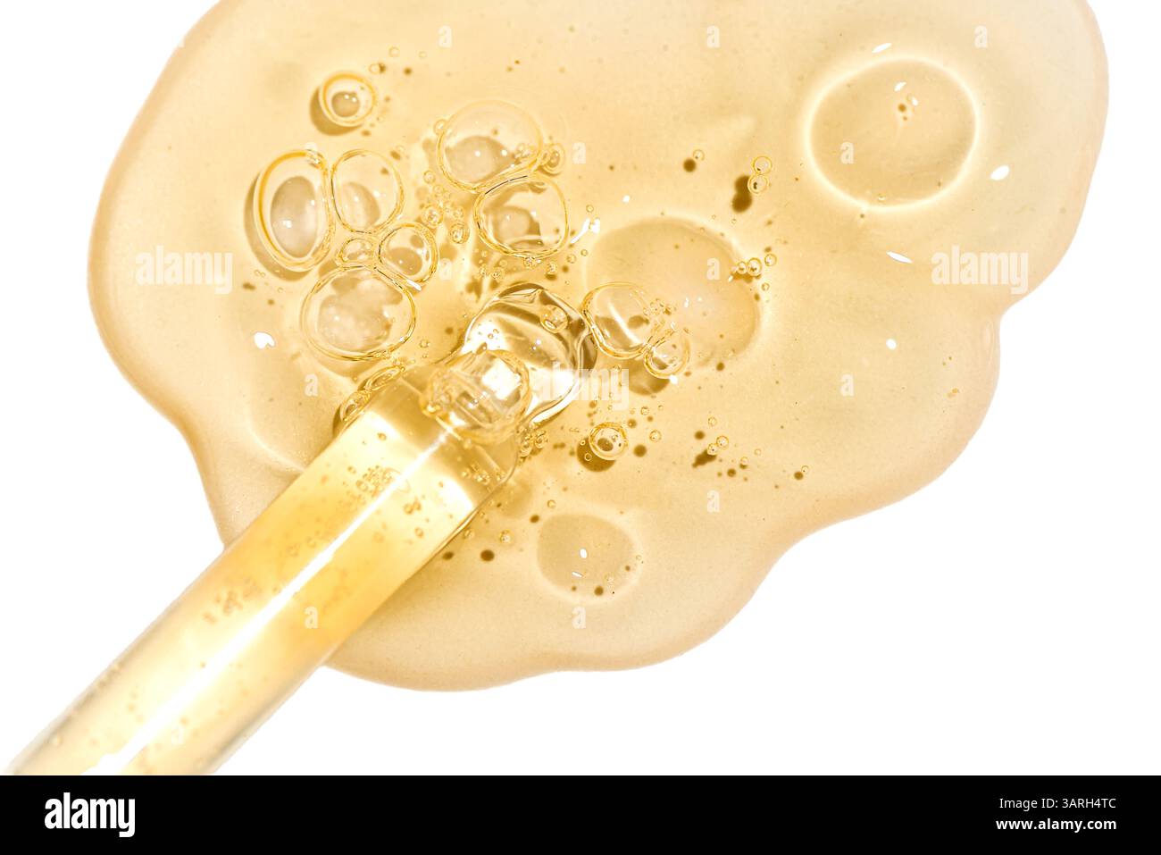 Pipette compte-gouttes et échantillon de sérum Golden face ou de gel de rétinol isolés sur fond blanc très rapprochés. Soin de la peau avec huile ou peptide. Texture Banque D'Images