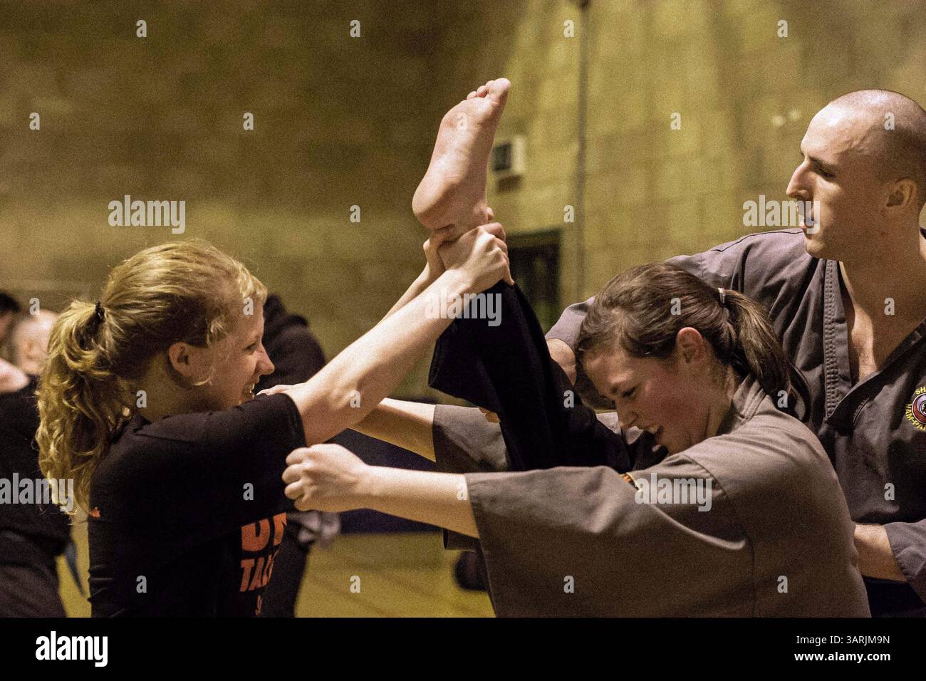 Jan 21, 2013 - Cardiff, South Wales, Royaume-Uni - dans le Nam-Pai-Chuan Kungfu Club à Cardiff, South Wales, pendant les exercices d'échauffement au début du cours, l'étudiante SARA SUTTON est aidée par ses partenaires à lever la jambe aussi haut que possible afin d'obtenir une meilleure flexibilité physique. (Crédit image : © Jiwei Han/ZUMAPRESS.com) Banque D'Images