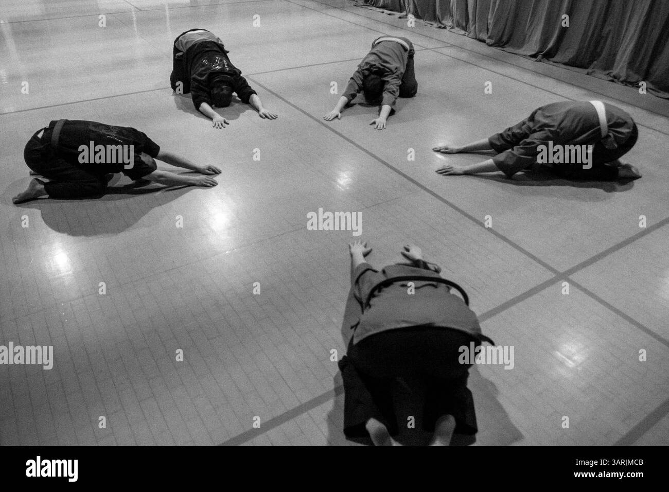 21 mars 2013 - Cardiff, pays de Galles du Sud, Royaume-Uni - à l'intérieur du Nam-Pai-Chuan Kung Fu Club. Les élèves s'allongent sur le sol pour étirer leur taille pendant les exercices d'échauffement. (Crédit image : © Jiwei Han/ZUMAPRESS.com) Banque D'Images
