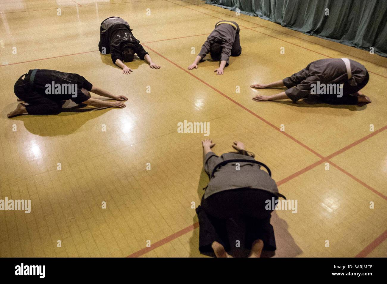 21 mars 2013 - Cardiff, pays de Galles du Sud, Royaume-Uni - à l'intérieur du Nam-Pai-Chuan Kung Fu Club, les étudiants s'allongent sur le sol pour étirer leur taille pendant les exercices d'échauffement. (Crédit image : © Jiwei Han/ZUMAPRESS.com) Banque D'Images