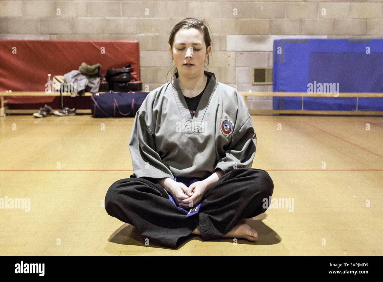 25 mars 2013 - Cardiff, Galles du Sud, Royaume-Uni - à l'intérieur du Nam-Pai-Chuan Kung Fu Club. L'étudiante SARA SUTTON est assise sur le sol pour repenser ce qu'elle a appris aujourd'hui. Les étudiants le feront dans les dernières minutes avant la fin du cours. (Crédit image : © Jiwei Han/ZUMAPRESS.com) Banque D'Images