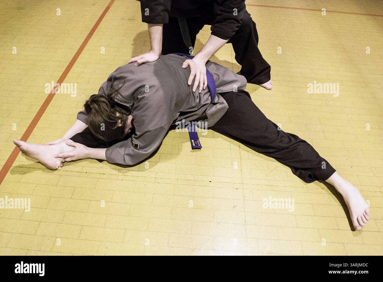 14 mars 2013 - Cardiff, Galles du Sud, Royaume-Uni - à l'intérieur du Nam-Pai-Chuan Kung Fu Club, Sifu NICK CHOWN aide l'étudiante SARA SUTTON à presser sa taille vers le bas pour se rapprocher de sa jambe afin d'obtenir une meilleure flexibilité corporelle. (Crédit image : © Jiwei Han/ZUMAPRESS.com) Banque D'Images