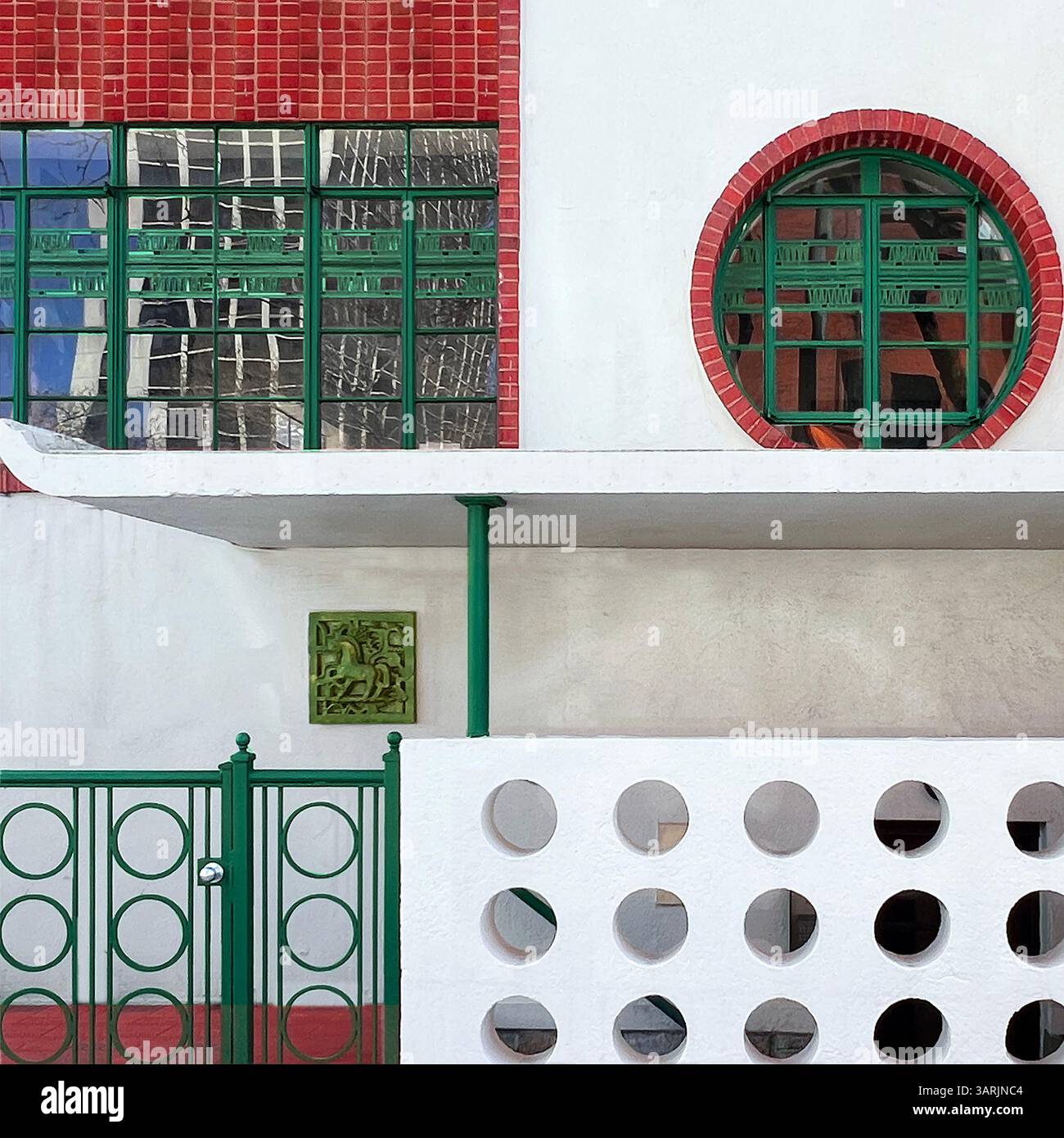 Façade moderne et colorée avec métallurgie verte géométrique, découpes circulaires et éléments architecturaux rouges et blancs audacieux à Chicago Banque D'Images