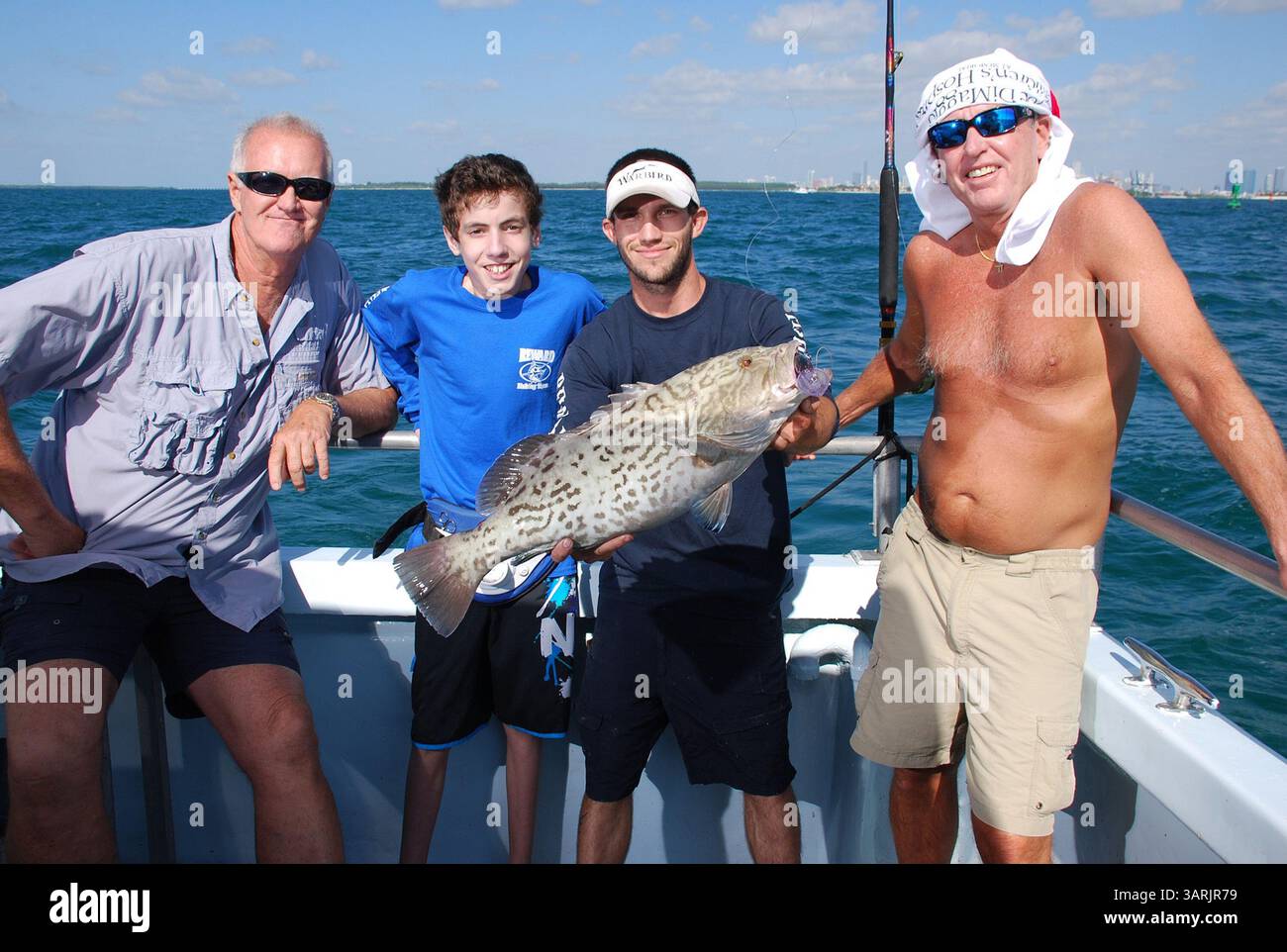 15 mai 2013 - Miami Beach, FL, États-Unis - Capitaine Wayne Conn, à gauche, Yan Andrade, son compagnon Chris Temmet et Rob Hoopes posent avec le mérou bâillon de 26 pouces qu'Andrade lors de son premier voyage de pêche au large de la côte de Miami Beach, en Floride. Andrade, qui a la fibrose kystique qui rend la respiration difficile, a pêché dans les canaux d'eau douce près de chez lui mais n'avait jamais été au large auparavant. (Crédit image : © Steve Waters/MCT/ZUMAPRESS.com) Banque D'Images