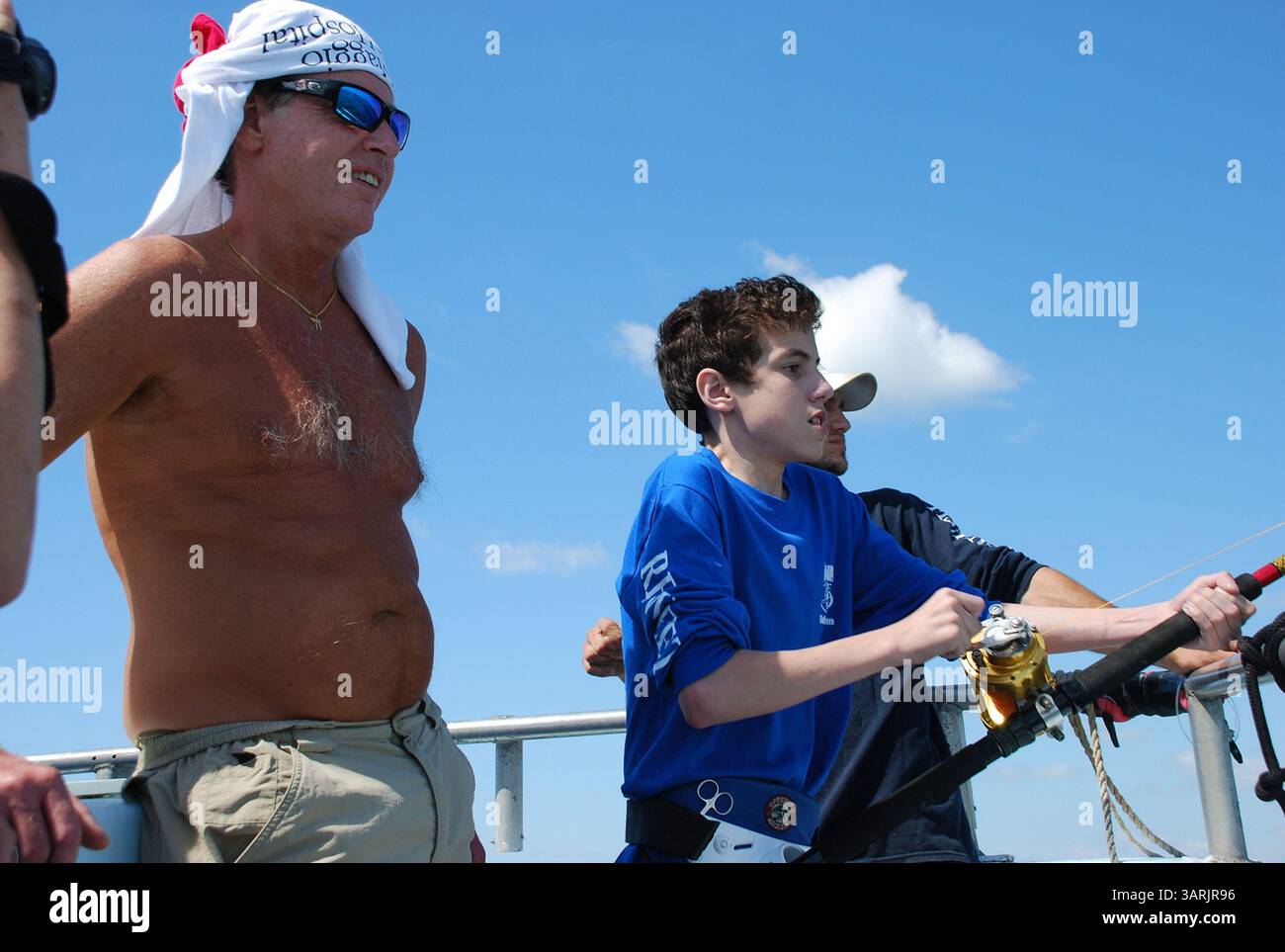15 mai 2013 - Miami Beach, FL, États-Unis - Yan Andrade, 16 ans, combat un poisson alors que Rob Hoopes, à gauche, et son compagnon Chris Temmeton regarde lors de son premier voyage de pêche au large de la côte de Miami Beach, en Floride. Andrade, qui a la fibrose kystique qui rend la respiration difficile, a pêché dans les canaux d'eau douce près de chez lui mais n'avait jamais été au large auparavant. (Crédit image : © Steve Waters/MCT/ZUMAPRESS.com) Banque D'Images