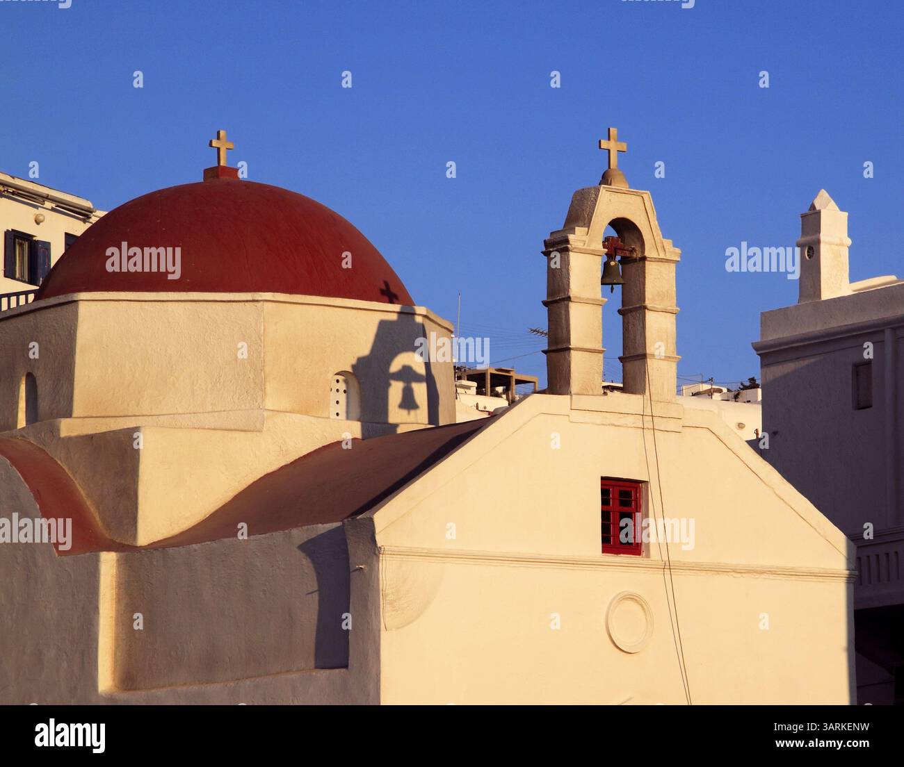 Grèce, îles grecques, Cyclades, Mykonos ou Mikonos. Façade et dôme d'une chapelle orthodoxe grecque typique éclairée par le coucher du soleil. Banque D'Images Grèce, îles grecques, Cyclades, Mykonos ou Mikonos. Façade et dôme d'une chapelle orthodoxe grecque typique éclairée par le coucher du soleil. Banque D'Images