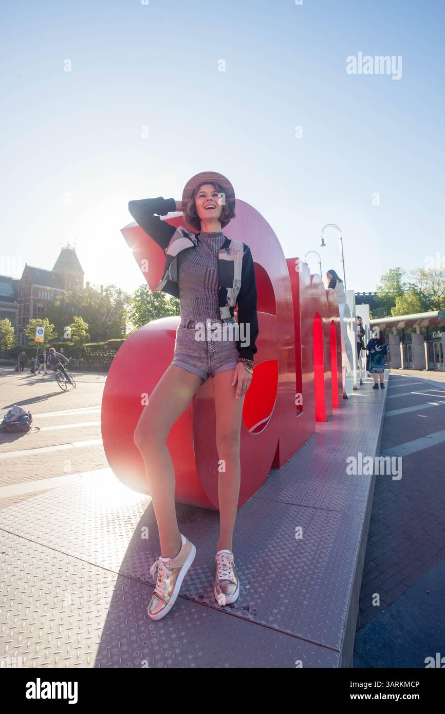 Couple sportif silhouettes homme et femme faisant une pose de yoga acrobatique sur l'herbe devant un beau coucher de soleil sur la mer. Banque D'Images