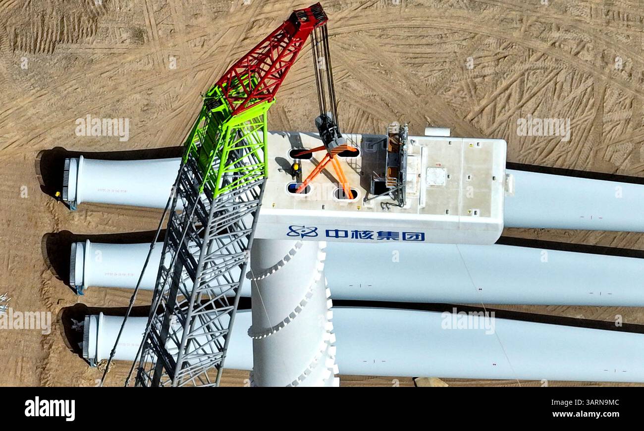 ZHANGYE, CHINE - 17 AVRIL 2025 - sur le site de construction du projet éolien de 100 000 kilowatts de Xinruisheng New Energy à Yanchi Beach, les constructeurs installent l'unité principale de l'éolienne sur une tour de 120 mètres de haut dans la ville de Zhangye, province du Gansu, Chine, le 17 avril 2025. Banque D'Images