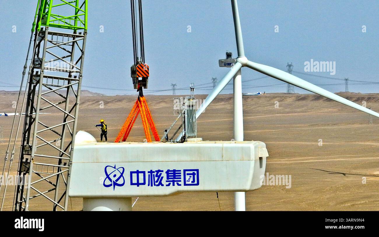ZHANGYE, CHINE - 17 AVRIL 2025 - sur le site de construction du projet éolien de 100 000 kilowatts de Xinruisheng New Energy à Yanchi Beach, les constructeurs installent l'unité principale de l'éolienne sur une tour de 120 mètres de haut dans la ville de Zhangye, province du Gansu, Chine, le 17 avril 2025. Banque D'Images