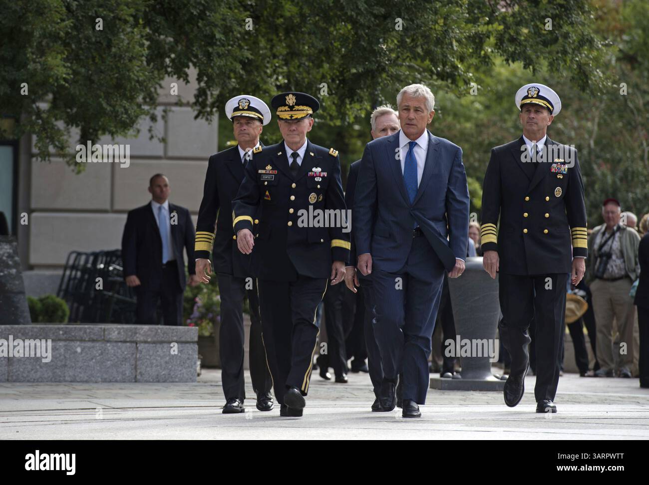 17 septembre 2013 - le Navy Memorial Plaza, Washington D. C - le secrétaire américain à la Défense Chuck Hagel et le président des chefs d'état-major interarmées, le général Martin Dempsey, se tiennent en compagnie du chef des opérations navales, l'amiral Jonathan Greenert et du secrétaire à la Marine Ray Mabus, alors que des taps sont joués lors d'une cérémonie de dépôt de couronne au Mémorial de la Marine. Les chefs de la défense ont organisé la petite cérémonie pour se souvenir des 12 victimes de la fusillade du Navy Yard qui a eu lieu la veille. La couronne a été placée à côté de ''The Lone Sailor'' qui représente ''toutes les personnes qui ont déjà servi, servent maintenant, ou qui doivent encore servir Banque D'Images