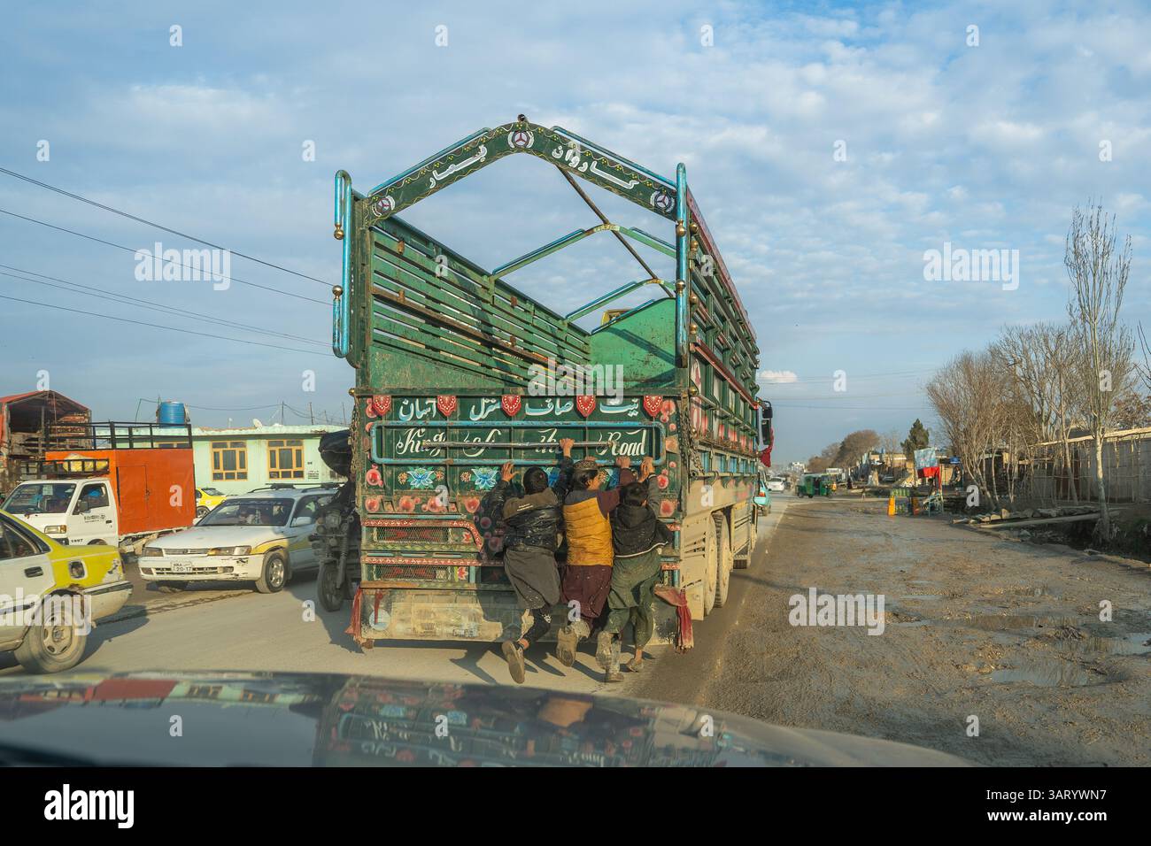 Un camion sur la route Balkh-Mazar-i-Sharif et des garçons coquins Banque D'Images
