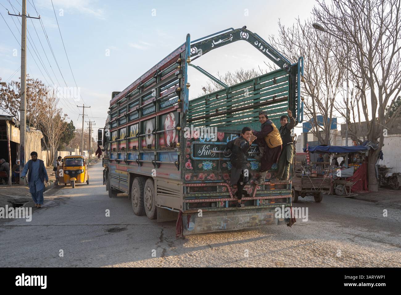 Un camion sur la route Balkh-Mazar-i-Sharif et des garçons coquins Banque D'Images