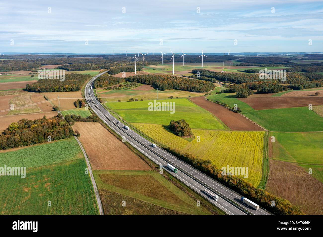 Drone vue aérienne en automne avec une autoroute à deux voies et des éoliennes à l'horizon Banque D'Images