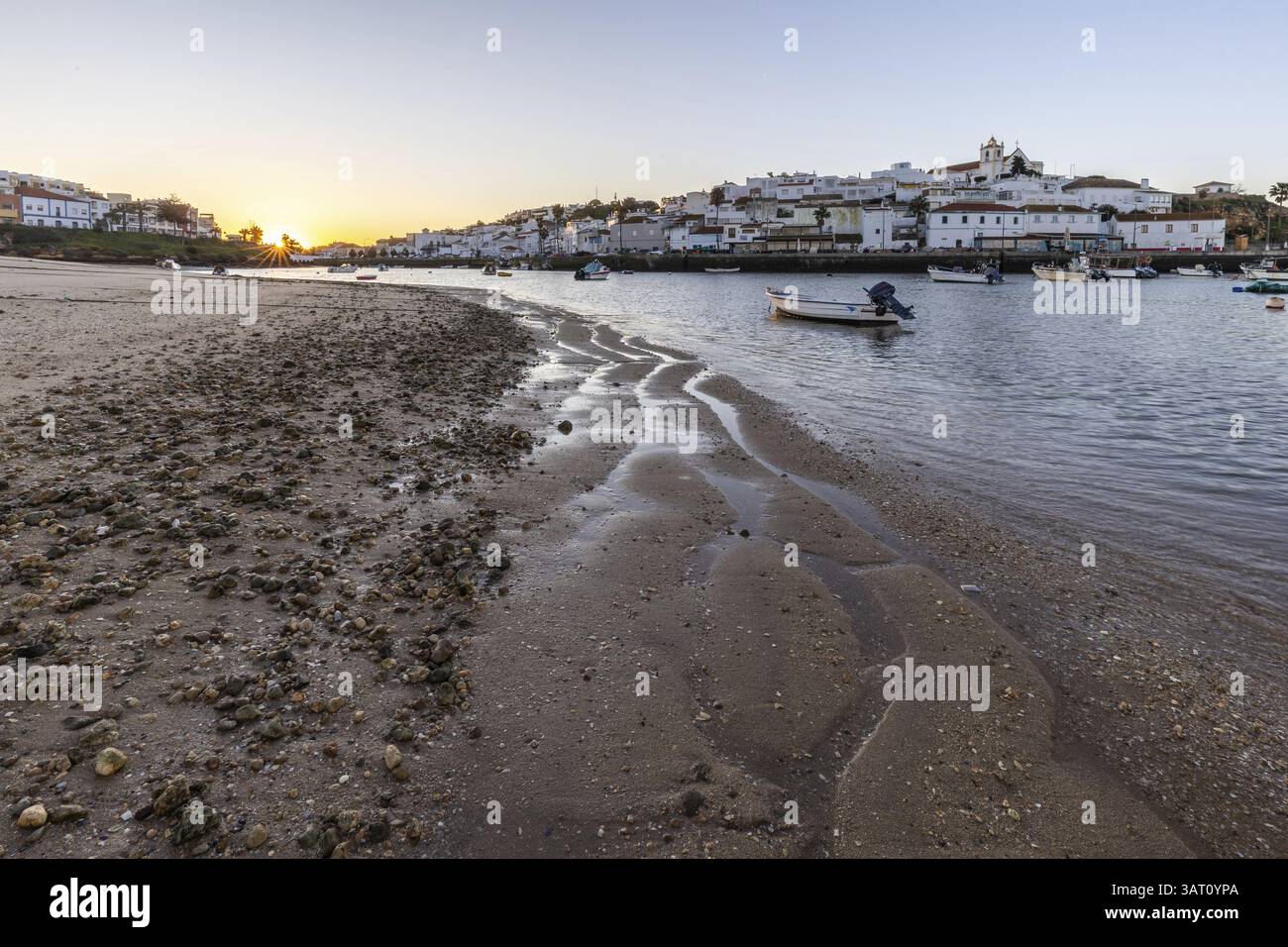 Lever de soleil avec vue sur la plage et le port à marée basse. Photo panoramique d'une vieille ville historique à l'aube à Ferragudo, Portimao, Algarve, Portugal, E. Banque D'Images