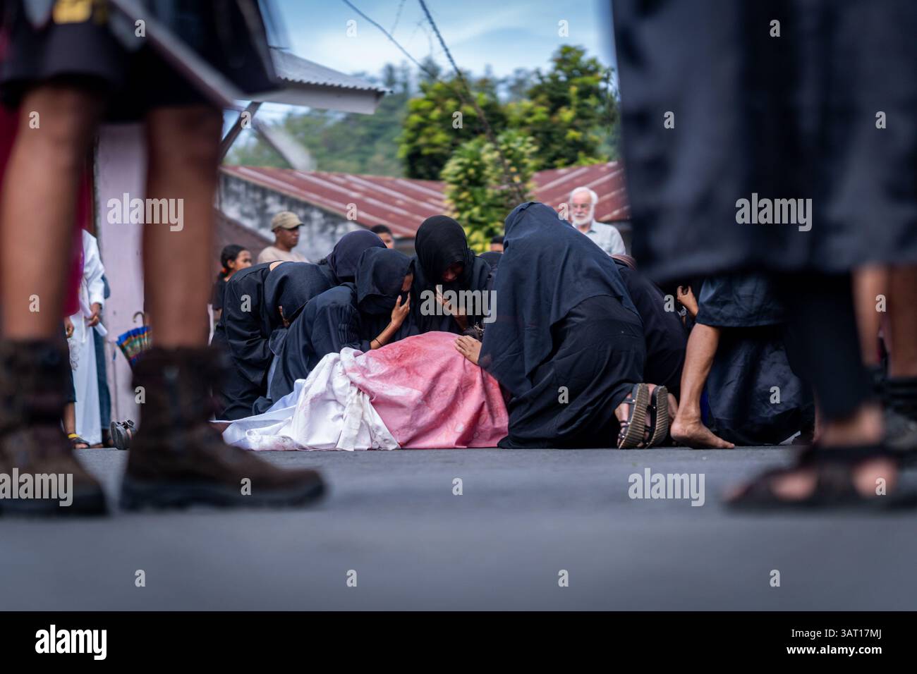 Les dévots prennent part à une procession du vendredi Saint, marchant à travers la ville dans un rituel solennel riche en éléments culturels catholiques et traditionnels locaux. Banque D'Images