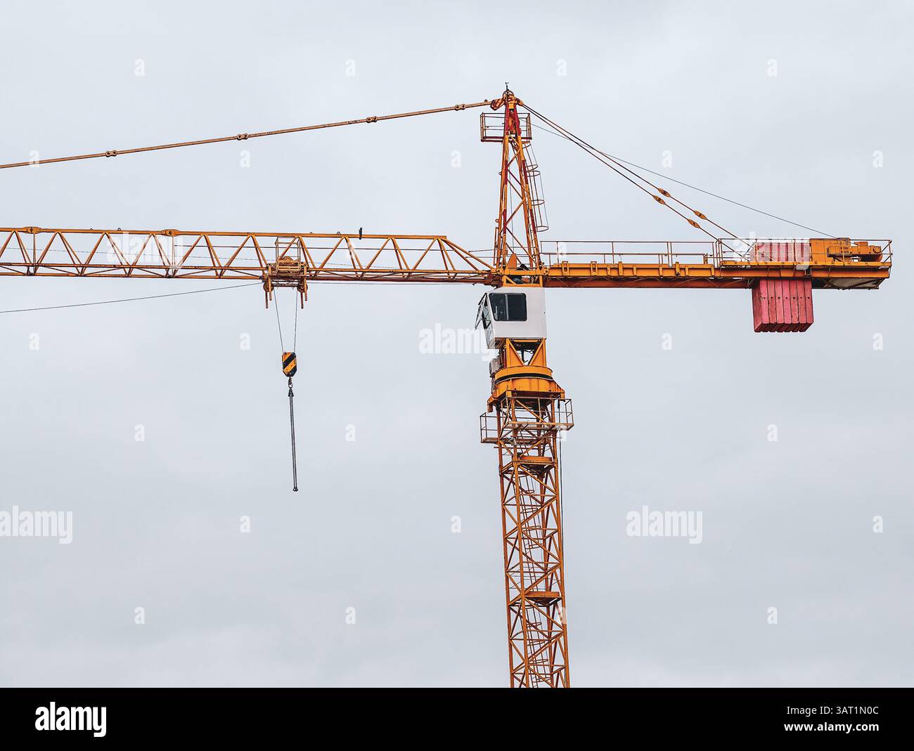Grue à tour contre ciel nuageux. Équipement de construction industrielle parfait pour les projets de développement urbain. Banque D'Images