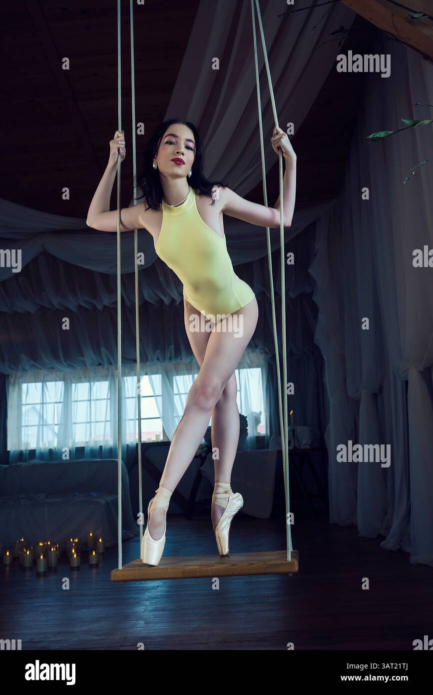 Une photo romantique d'une ballerine, d'une ballerine en chaussures pointe se balançant sur une balançoire, d'une ballerine en léopard Banque D'Images