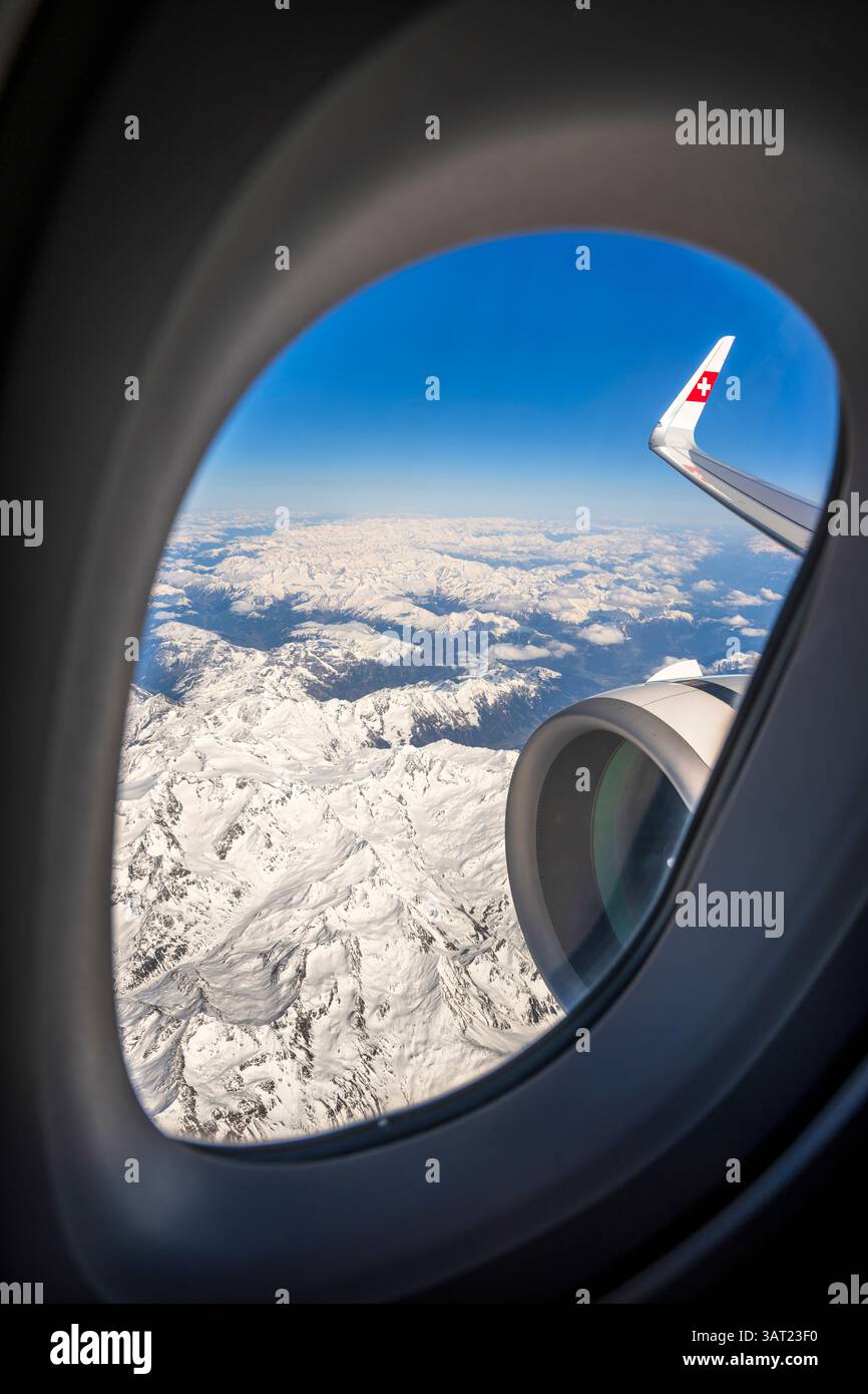 Vue sur les Alpes suisses enneigées depuis une fenêtre d'avion Banque D'Images