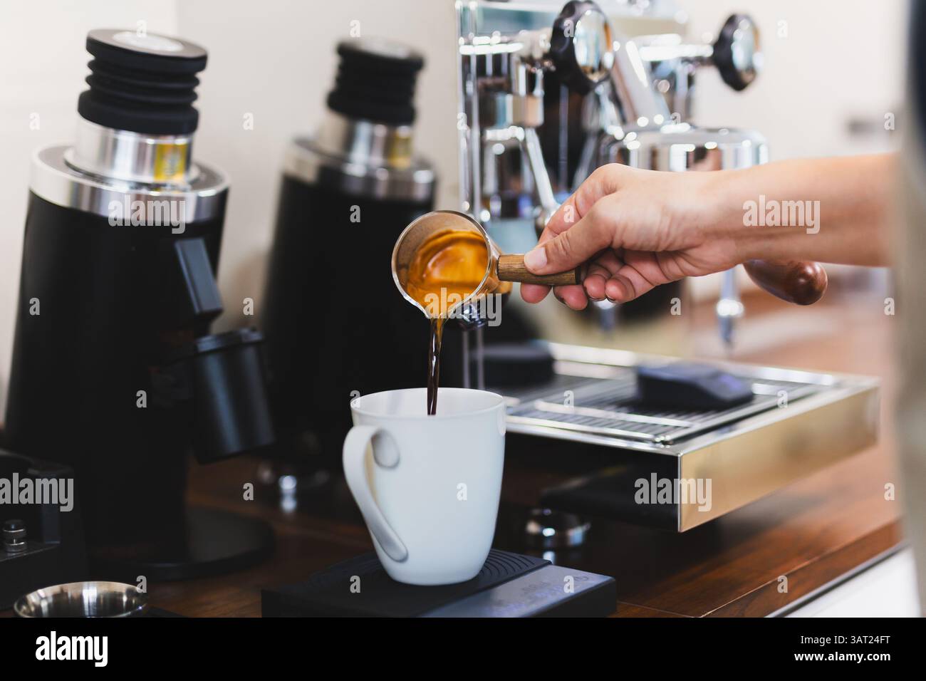 Femme barista versant du café chaud dans la tasse blanche. Banque D'Images