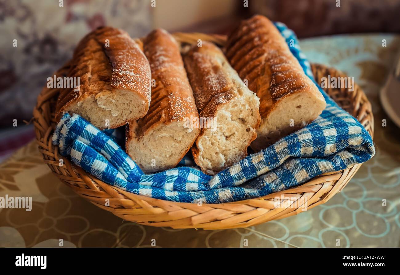 Khobz marocain – pain artisanal frais dans un panier avec tissu à carreaux bleu Banque D'Images