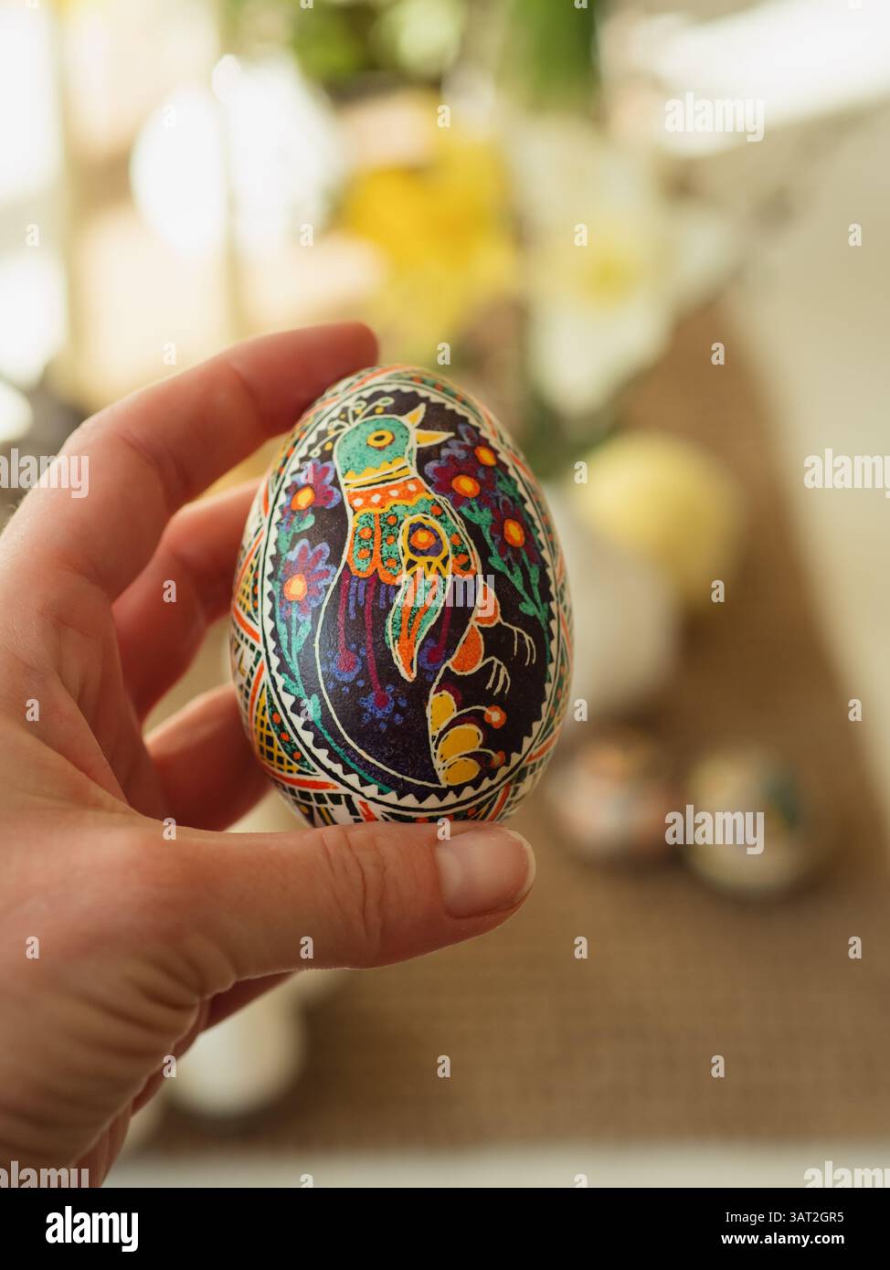 Main tenant un pysanka avec motif floral et oiseau magique complexe Banque D'Images