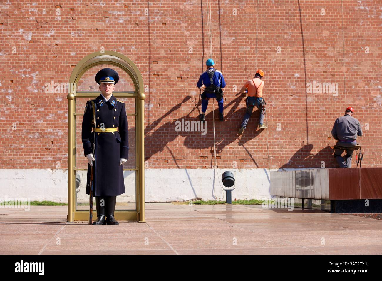 Moscou, Russie - 16 avril 2025 : soldat russe en service sur fond de réparation d'ouvriers de construction sur le mur du Kremlin Banque D'Images
