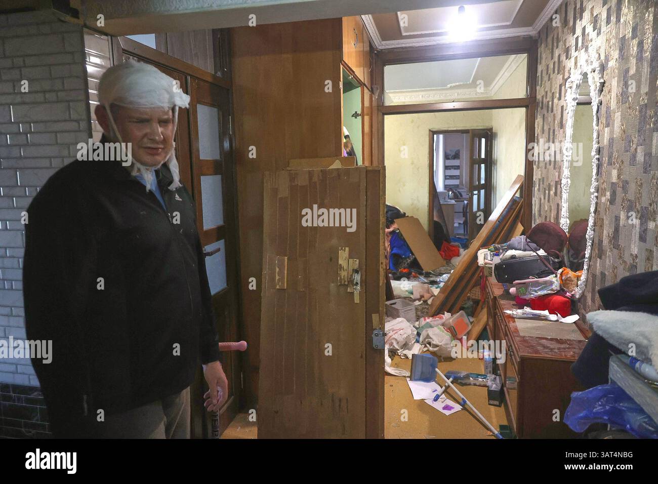 Un homme à la tête bandée séjourne dans un appartement endommagé par une attaque de missiles balistiques russes à Kharkiv, en Ukraine, le 18 avril 2025. Les troupes russes ont attaqué Kharkiv avec trois missiles balistiques à l'aube du vendredi 18 avril. L'attaque au missile a blessé 87 personnes, dont six enfants. Dix-sept personnes ont été admises dans les hôpitaux locaux, dont une fille de 4 ans, un garçon d'un an et une fille de 14 ans. Actuellement, trois des blessés sont dans un état critique. Une personne est morte. (Photo de Viacheslav Madiievskyi/Ukrinform) Banque D'Images