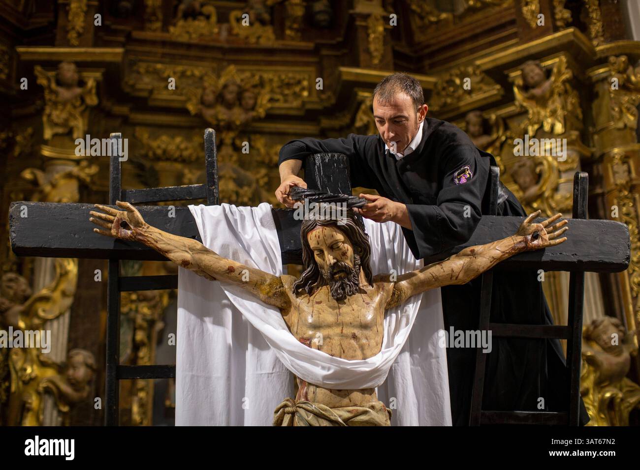 Sahagun, Léon, Espagne. 18 avril 2025. Un membre des confréries de notre Père Jésus de Nazareth et patronage de Saint Joseph pose une couronne d’épines sur la tête du Christ sur la croix devant le retable de l’église de San Lorenzo, en préparation de la Messe d’Adoration de la Croix et de l’acte de détachement avec le Christ, lors des activités du vendredi Saint à Sahagun. (Crédit image : © Luis Soto/ZUMA Press Wire) USAGE ÉDITORIAL SEULEMENT ! Non destiné à UN USAGE commercial ! Crédit : ZUMA Press, Inc/Alamy Live News Banque D'Images