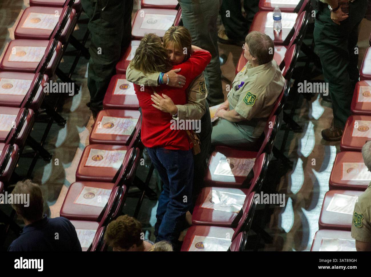 09 juil. 2013 - Prescott Valley, Arizona, États-Unis - Un travailleur de Prescott National Forest reçoit un câlin d'une femme non identifiée avant un service commémoratif au Tim's Toyota Center à Prescott Valley, Ariz. 19 membres de l'équipe Granite Mountain Hot Shot sont morts en combattant l'incendie de Yarnell Hills, à environ 40 miles au sud-ouest de Prescott, Ariz., juin 30. (Crédit image : © Michael Chow-POOL/The Arizona Republic/ZUMAPRESS.com) Banque D'Images