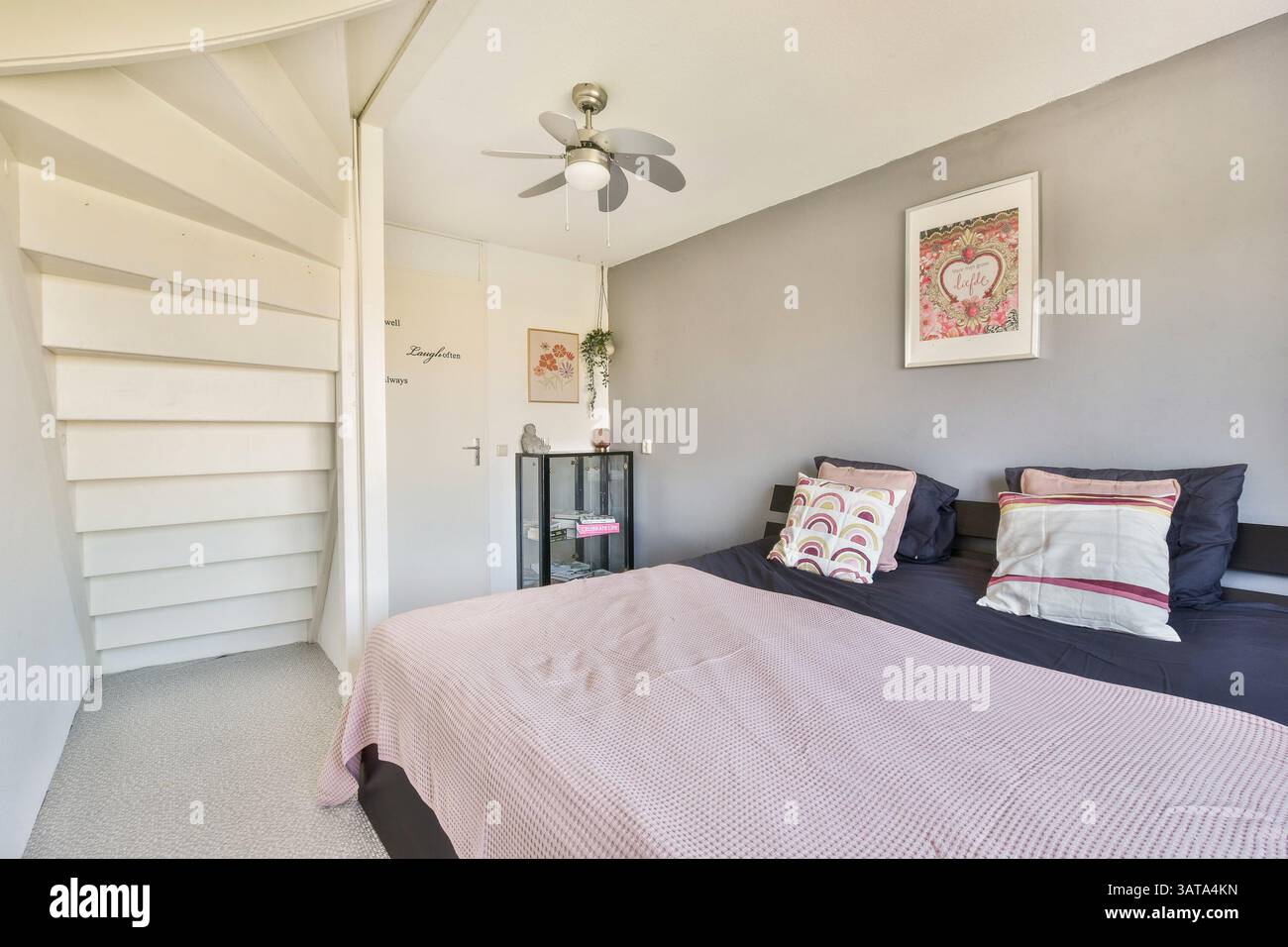 Une chambre moderne magnifiquement conçue avec des tissus d'ameublement, un décor élégant et une palette de couleurs apaisantes, créant un havre de paix parfait pour la détente. Banque D'Images