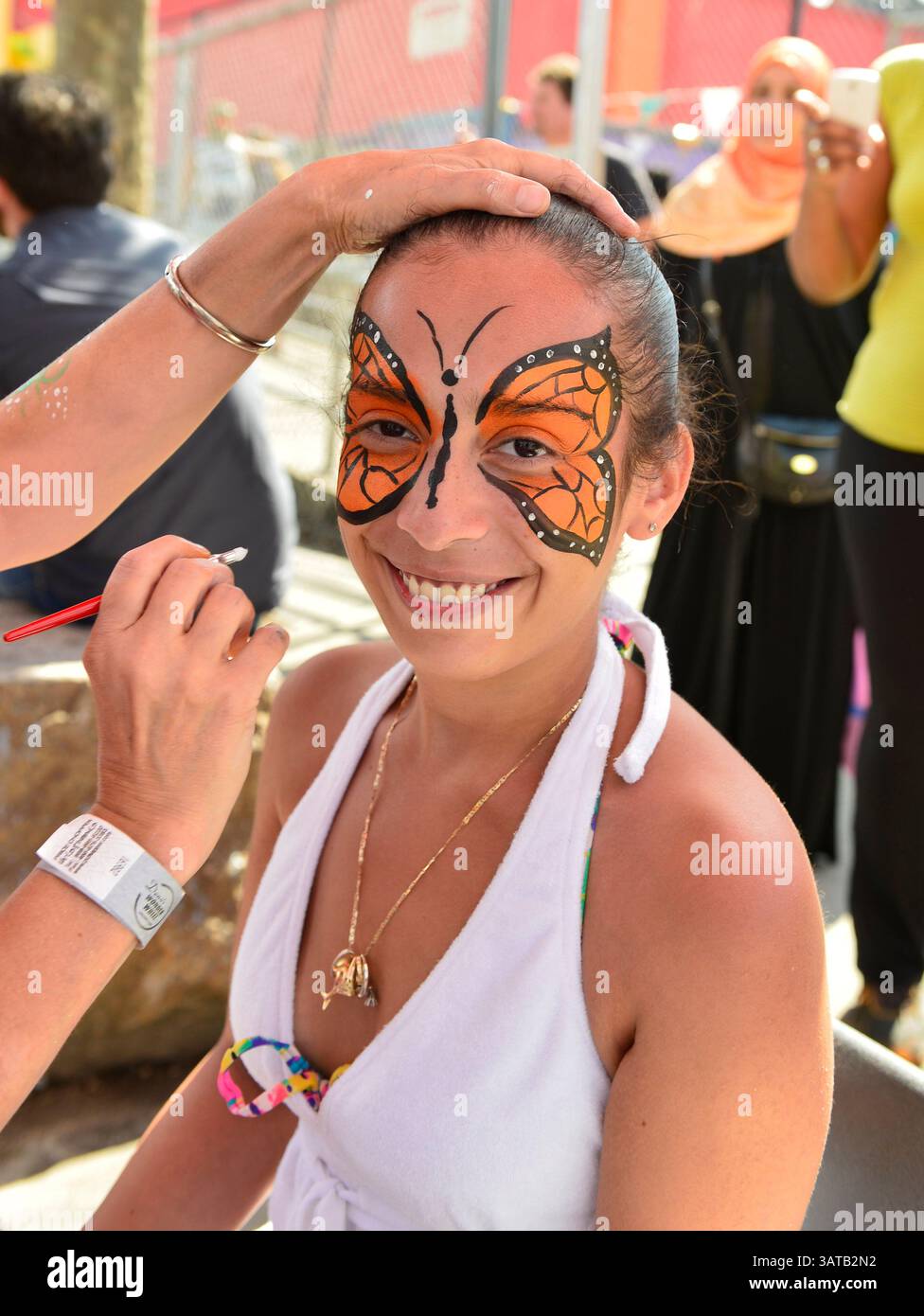10 août 2013 - Brooklyn, New York, États-Unis - une jeune femme souriante a un beau pinceau à papillon orange peint sur son visage par l'artiste bénévole Laura Yorburg, lors de la 3e célébration annuelle de la Journée de l'histoire de Coney Island. (Crédit image : © Ann Parry/ZUMA Wire) Banque D'Images