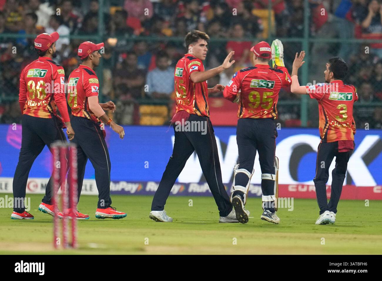 Punjab Kings players celebrate the wicket of Royal Challengers Bengaluru's Liam Livingstone during the Indian Premier League cricket match between Royal Challengers Bengaluru and Punjab Kings at Chinnaswamy Stadium in Bengaluru, India, Friday, April 18, 2025. (AP Photo/Aijaz Rahi) Banque D'Images