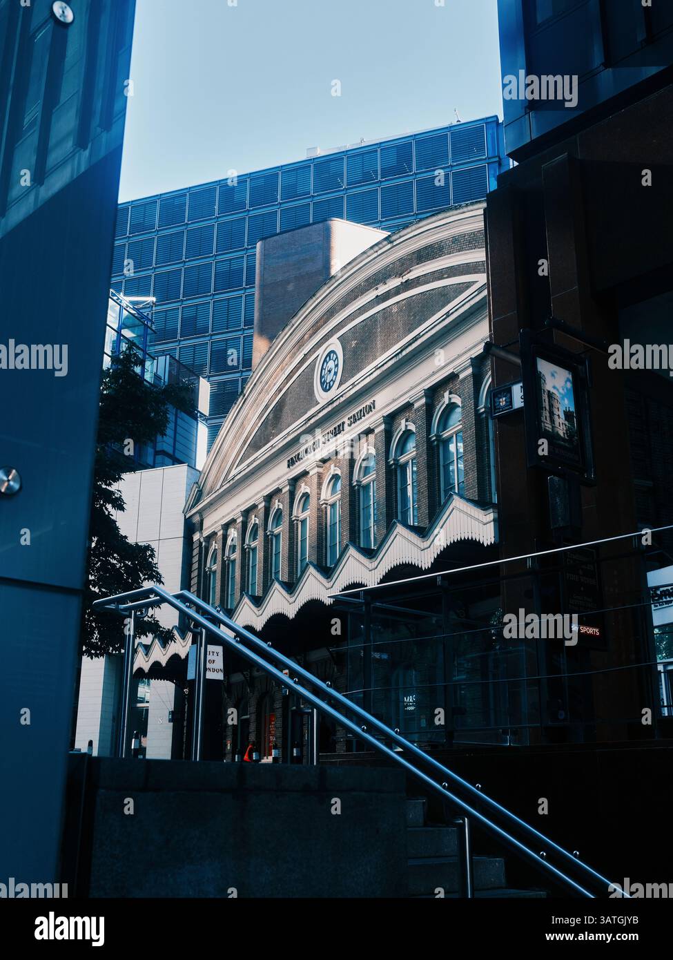 Londres, Royaume-Uni - 28 septembre 2024 : la façade originale de la gare de Fenchurch Street, entourée d'immeubles de bureaux en verre et en acier dans la ville de Londres Banque D'Images