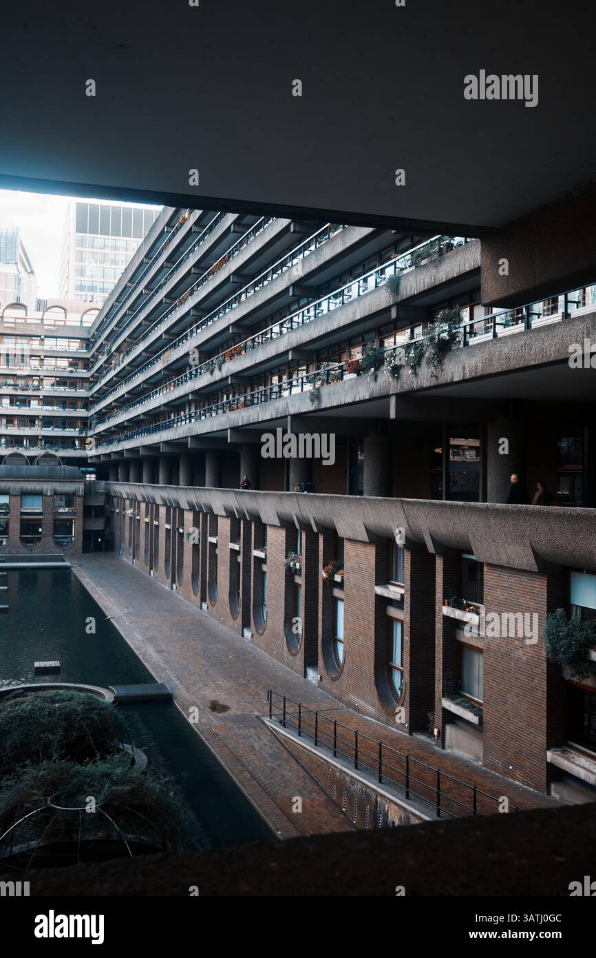 Londres, Royaume-Uni - 28 septembre 2024 : balcons résidentiels brutaux et passage de canal de Gilbert House dans le domaine Barbican, City of London, entouré Banque D'Images