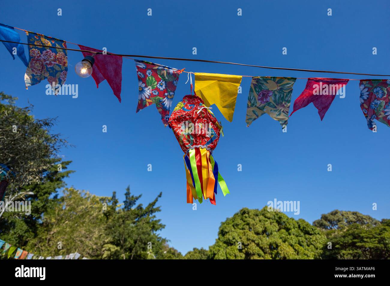 Les ballons et les drapeaux suspendus forment une scène multicolore et décorent une fête en plein air. Festival traditionnel brésilien de juin. Décoration de fête brésilienne. Banque D'Images