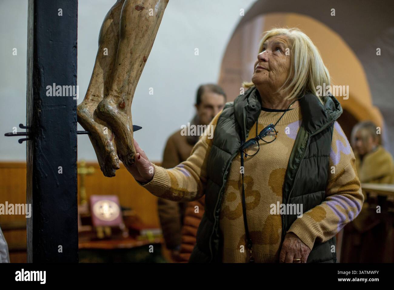 Sahagun, Léon, Espagne. 18 avril 2025. Un voisin touche avec respect les pieds de la statue articulée du Christ crucifié, lors de la messe à l'église de San Lorenzo et de la procession funéraire sainte dans les rues de Sahagun. (Crédit image : © Luis Soto/ZUMA Press Wire) USAGE ÉDITORIAL SEULEMENT ! Non destiné à UN USAGE commercial ! Banque D'Images