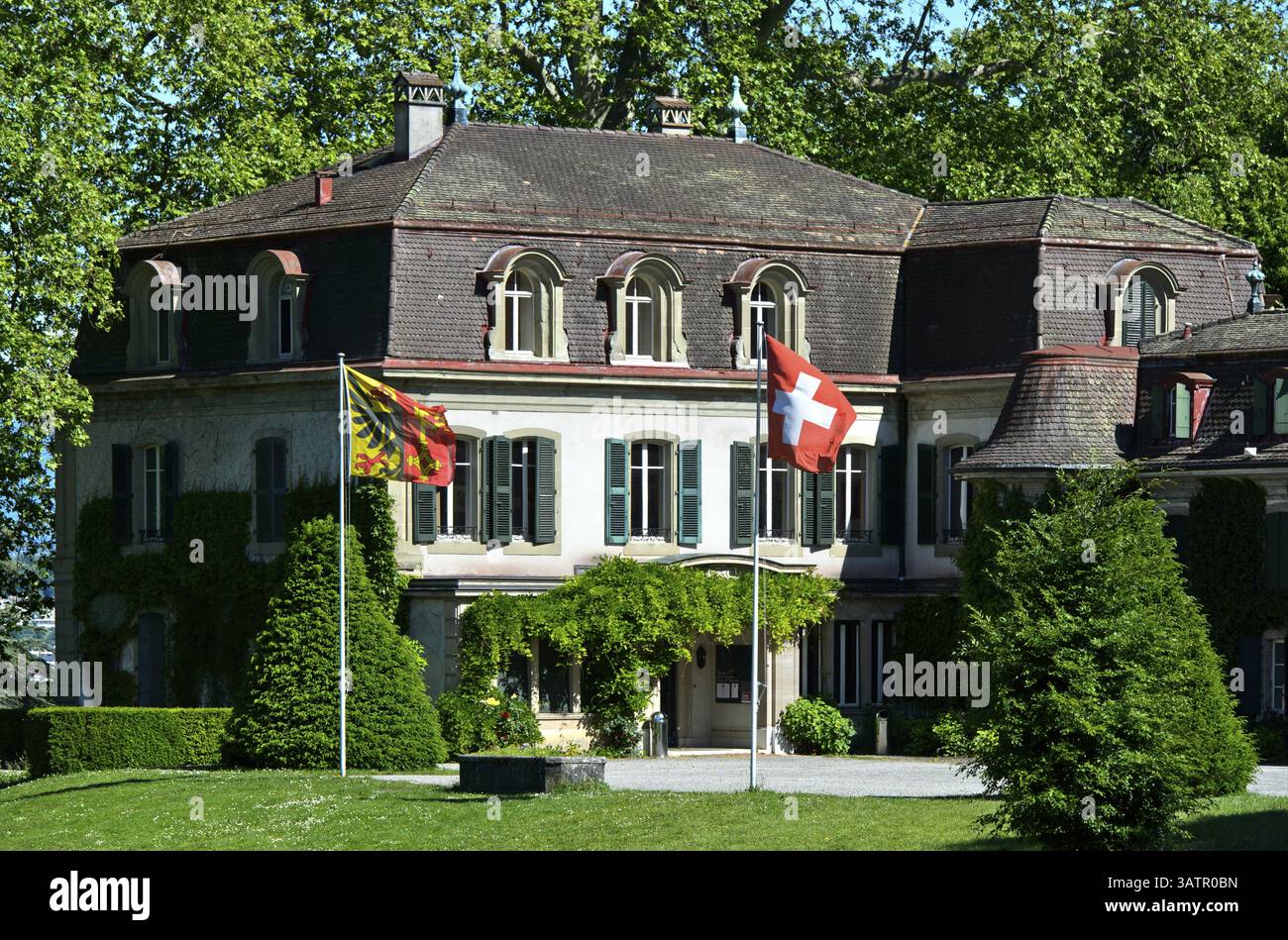 Château de Penthes avec le drapeau national suisse et le drapeau du canton de Genève dans le parc du domaine de Penthes, Pregny-Chambesy, Genève, Switze Banque D'Images