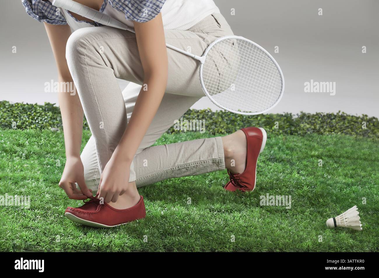 Jambes de femme, raquette de badminton et volant sur une herbe verte Banque D'Images